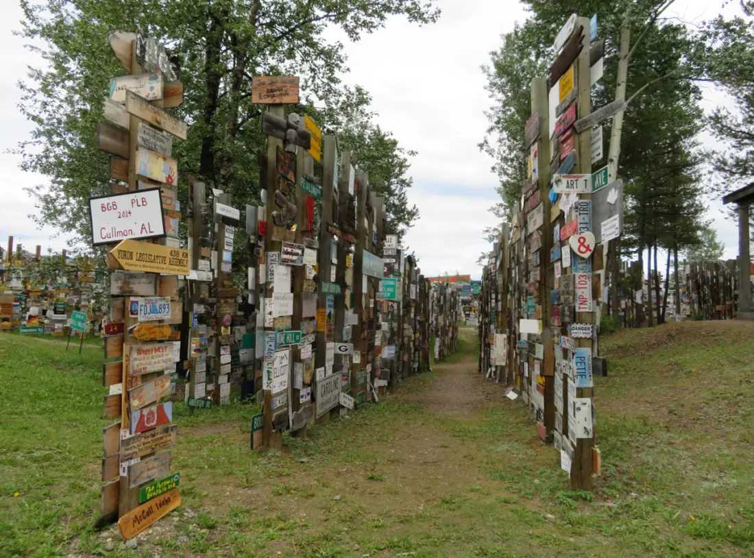 Dense poles covered in travellers destination signs at the Sign Post Forest in Watson Lake, Yukon