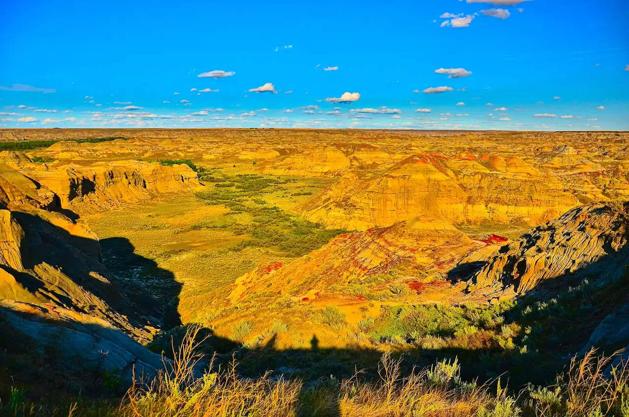 Eroded ridges of the Red Deer River badlands in Dinosaur Provincial Park glowing orange in low evening light