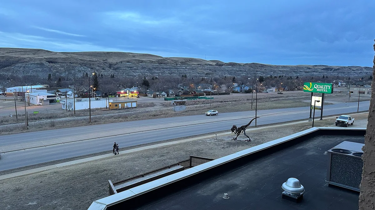 The town of Drumheller spread along the floor of the Red Deer River valley with eroded slopes rising behind it