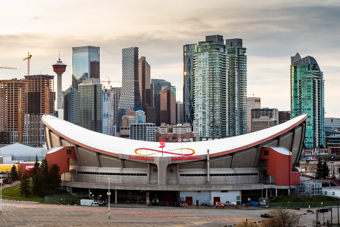 The curved concrete roof of the Scotiabank Saddledome arena in Calgary against a blue sky