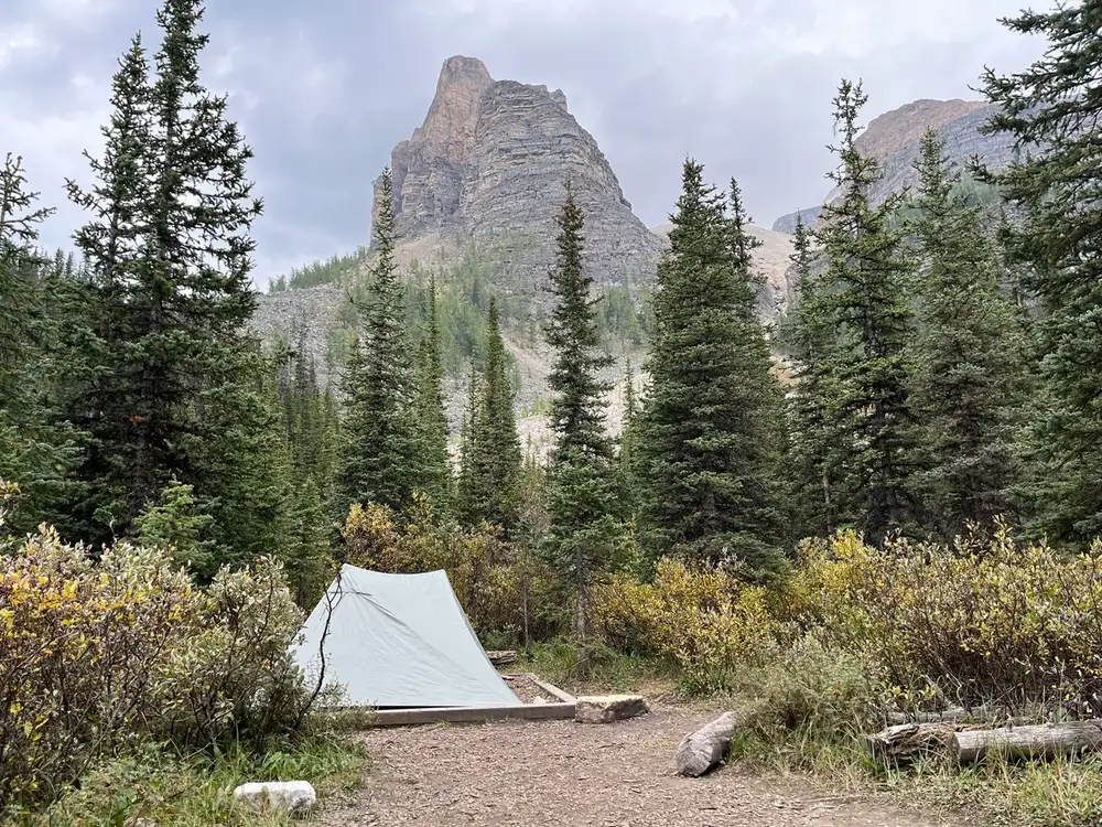 A small backpacking tent pitched on gravel below Ball Mountain in the Rockies