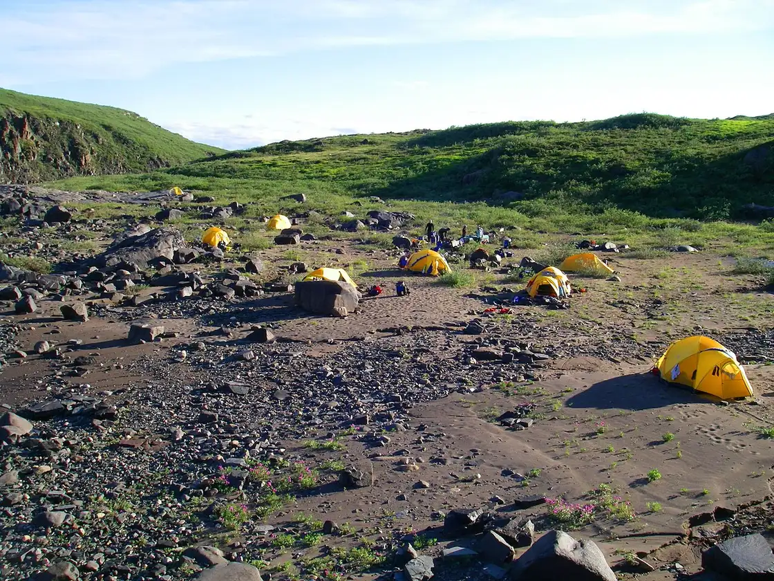 Tents pitched on open tundra beside a northern river at Bloody Falls in Nunavut