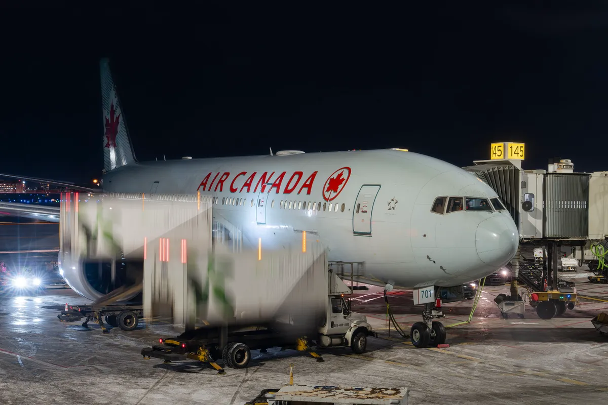 An Air Canada Boeing 777 wide-body jet parked on the apron under a pale sky
