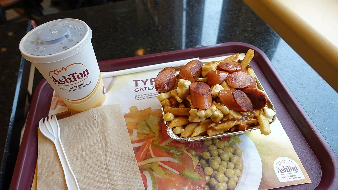 A tray of poutine with sausage, cheese curds and gravy on fries at a Chez Ashton counter in Quebec City