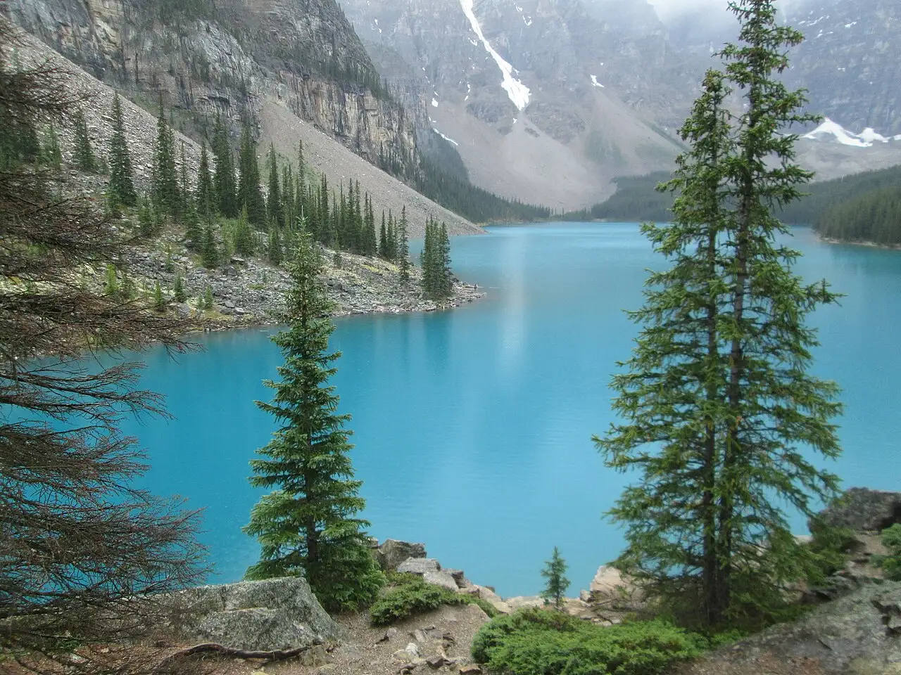 Moraine Lake and surrounding peaks under a partly cloudy sky in Banff National Park