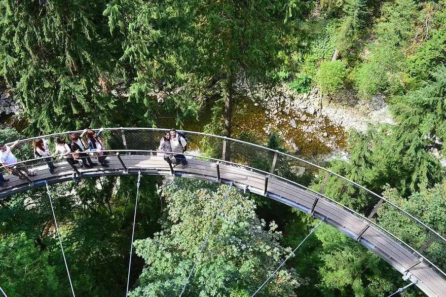 The narrow cantilevered Cliffwalk walkway clinging to a granite cliff above Capilano Canyon