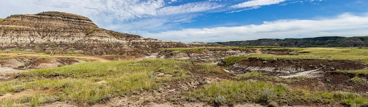 A wide panoramic view of eroded badlands hills and gullies near the Royal Tyrrell Museum outside Drumheller