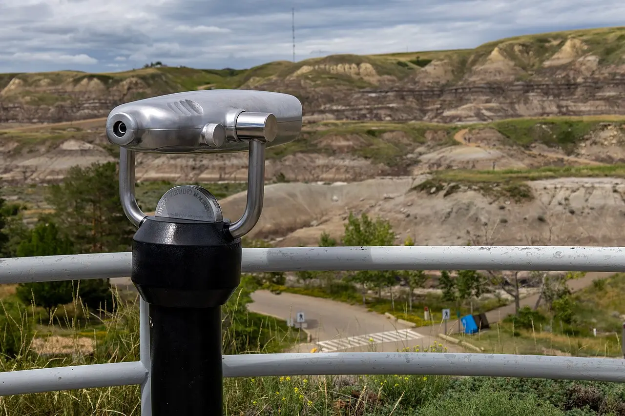 A coin-operated viewing scope overlooking the eroded badlands hills from the Royal Tyrrell Museum lookout