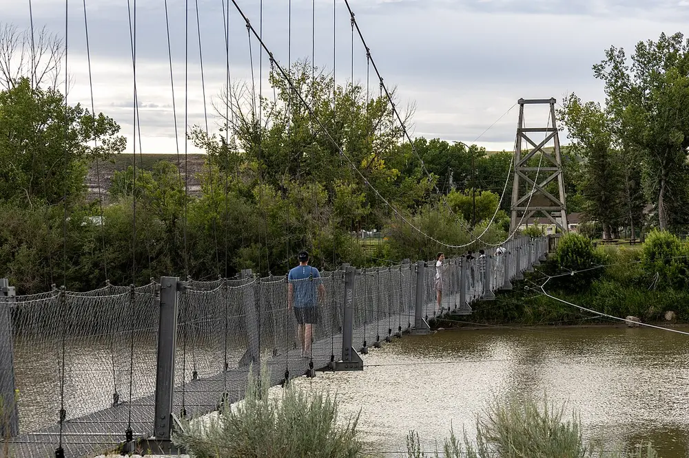 The long Star Mine Suspension Bridge crossing the Red Deer River near Rosedale, Alberta