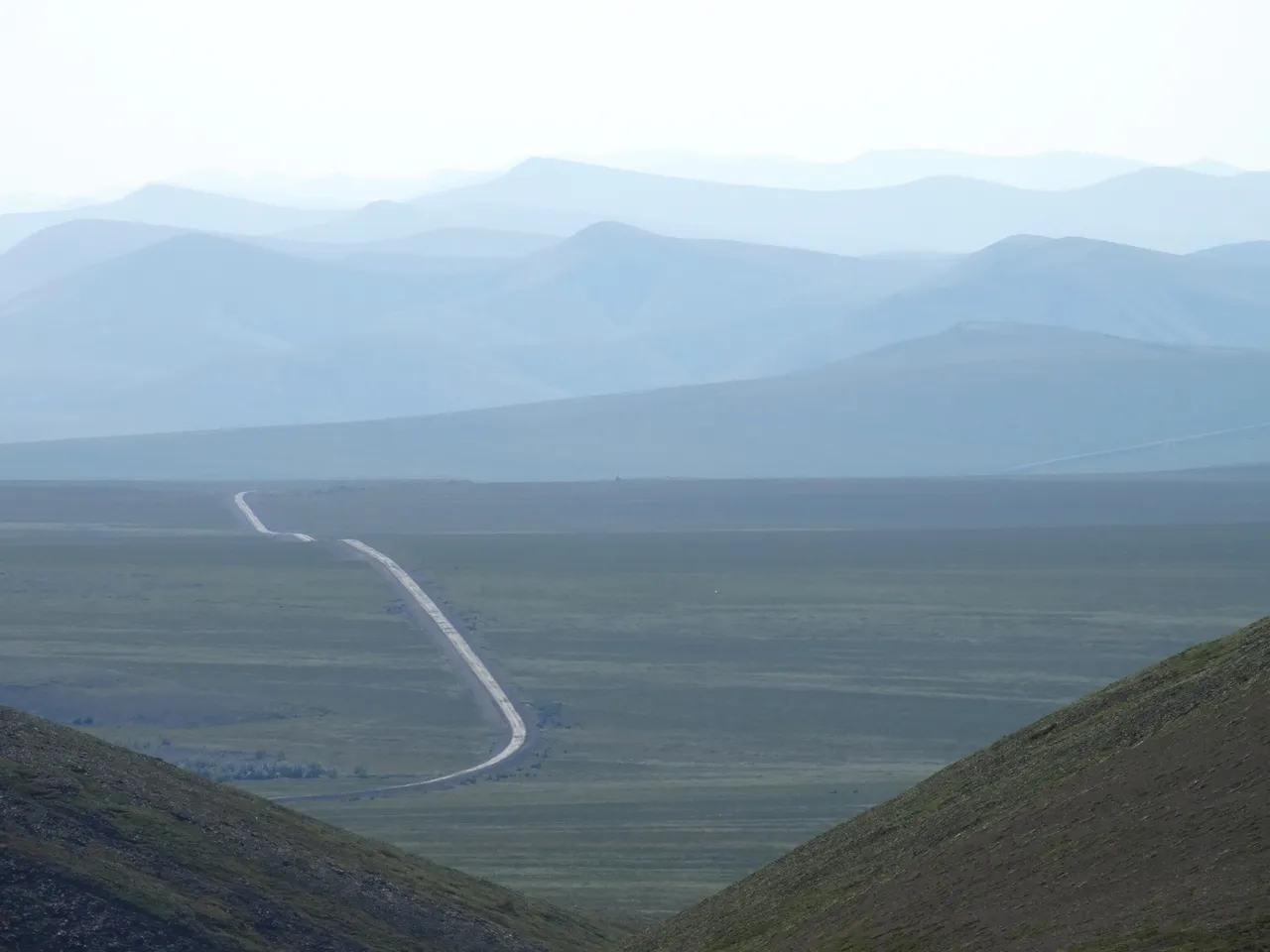 The gravel Dempster Highway stretching into empty mountains in the Northwest Territories