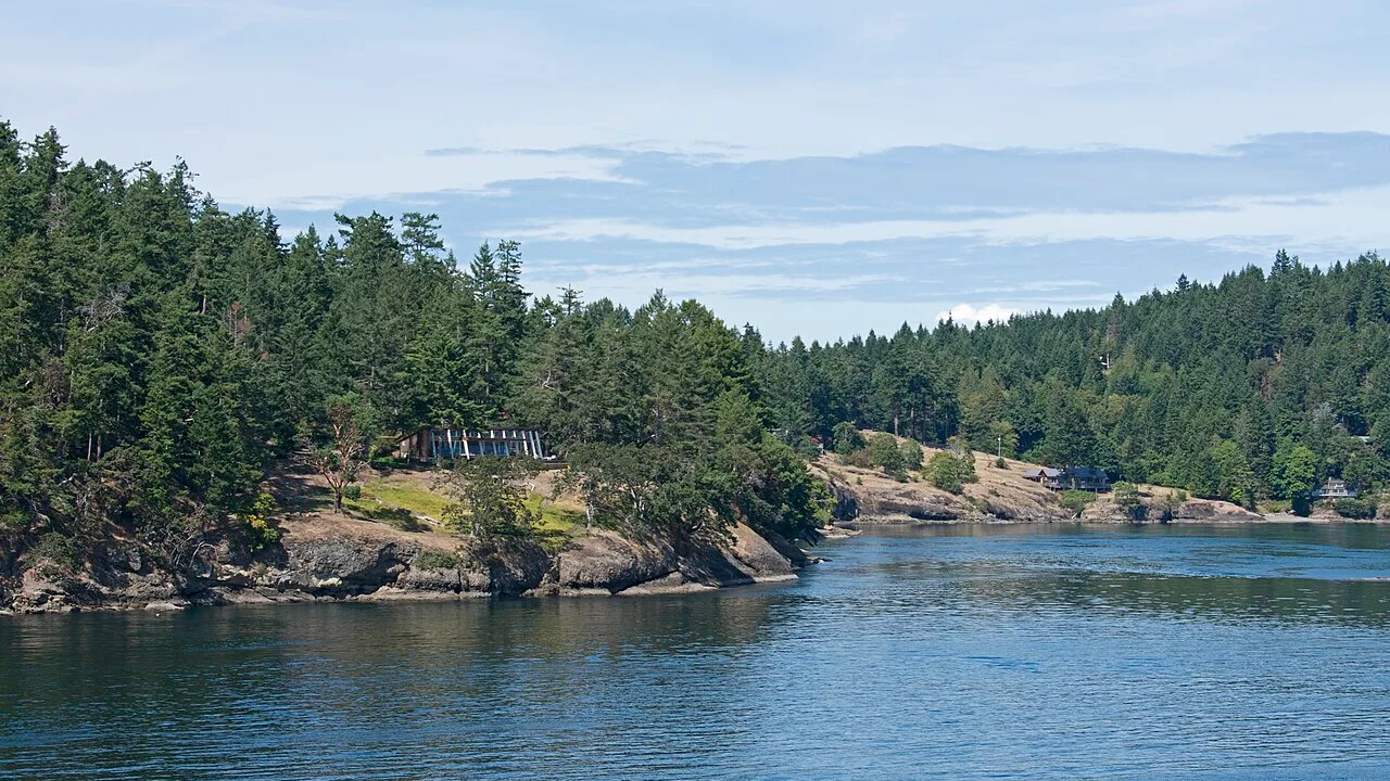 A BC Ferries sailing through Active Pass with forested Galiano Island on either side