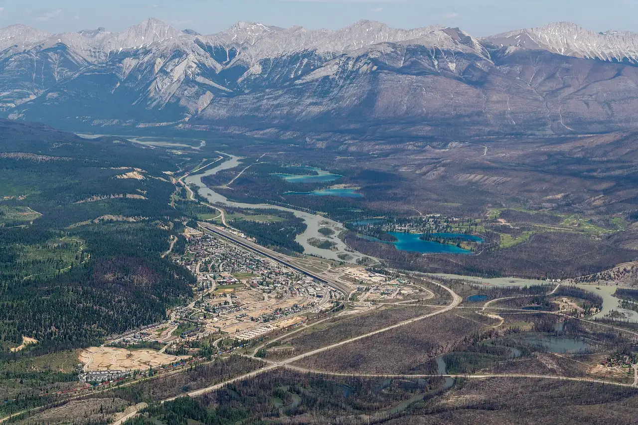 The Jasper townsite, the Athabasca River and a chain of turquoise lakes seen from high on Whistlers Mountain, with fire-scarred slopes on the right