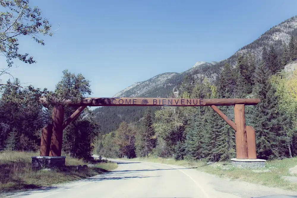 A wooden welcome sign spanning the Bow Valley Parkway road in Banff National Park
