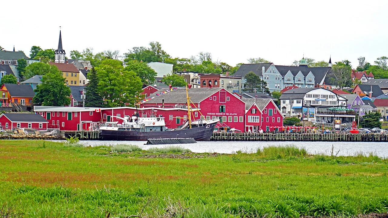 Colourful wooden waterfront buildings along Lunenburg harbour under a blue sky