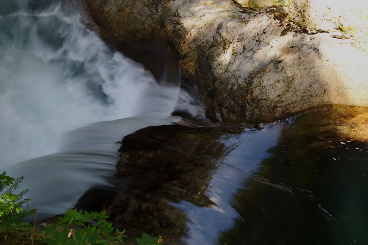 Twin Falls in Lynn Canyon with white water dropping into a pool between mossy canyon walls