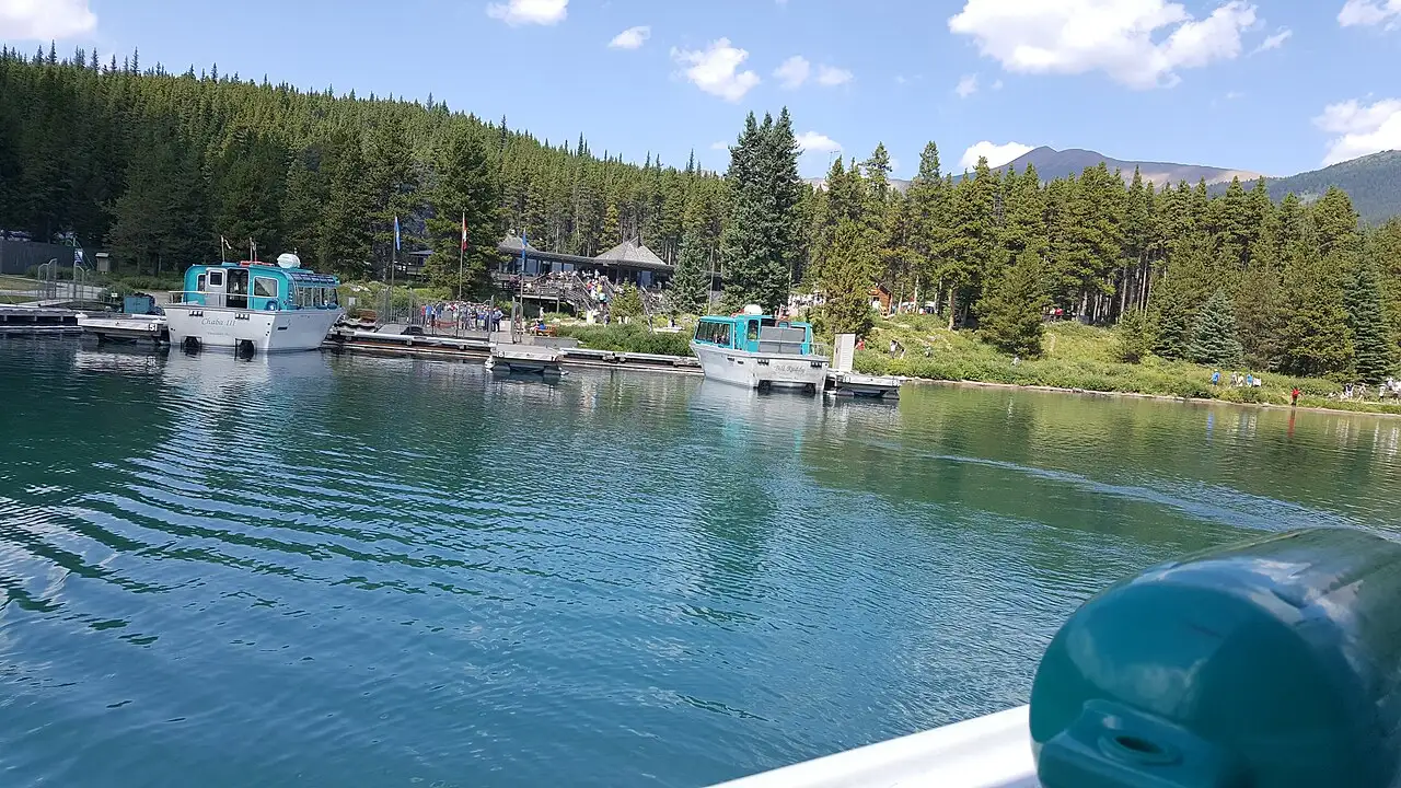 Two Maligne Lake Cruise tour boats docked near the visitor building at the north end of the lake