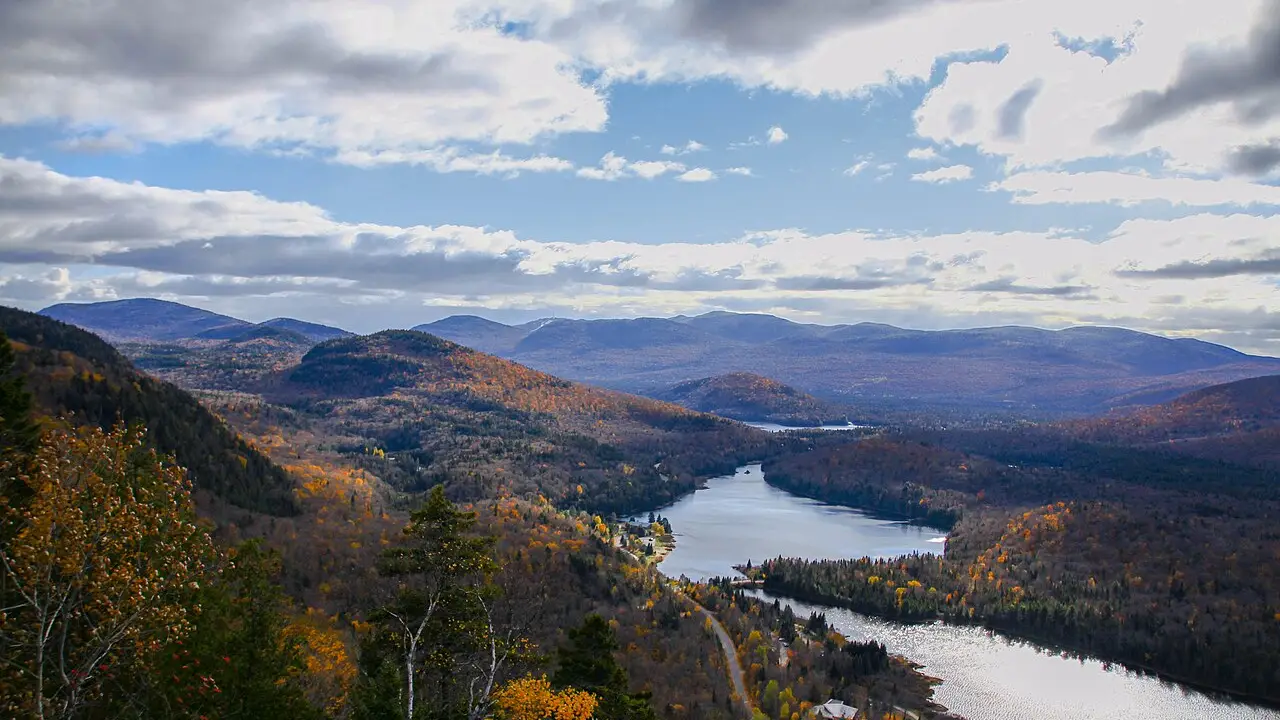 Autumn hills and a lake in the Laurentians near Mont-Tremblant under a pale sky