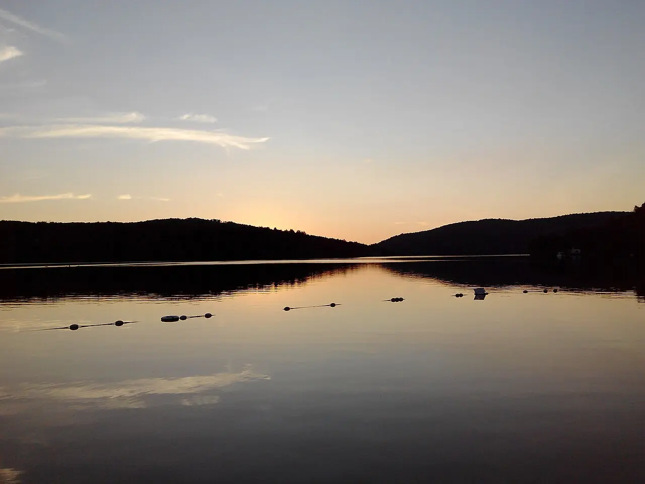 Lac Tremblant with forested hills and the resort mountain under a summer sky