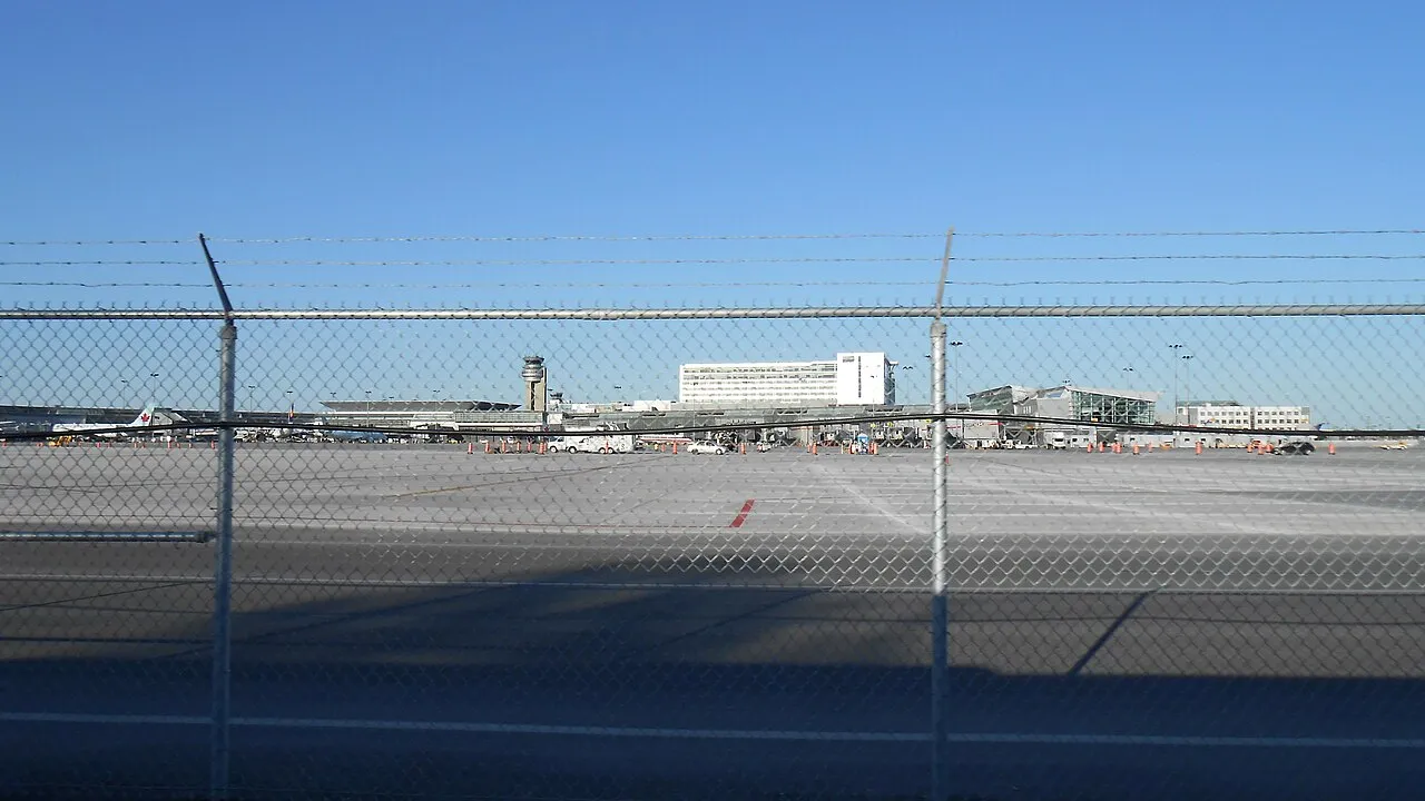 The terminal building at Montreal-Trudeau International Airport with cars along the arrivals curb