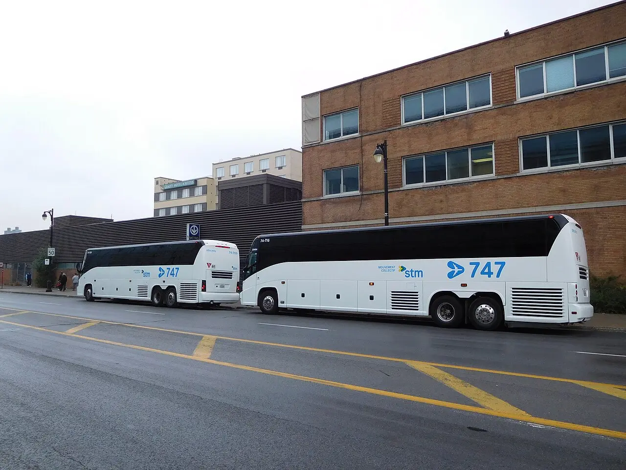 An STM 747 shuttle bus parked at a stop, the dedicated airport express route between YUL and downtown Montreal