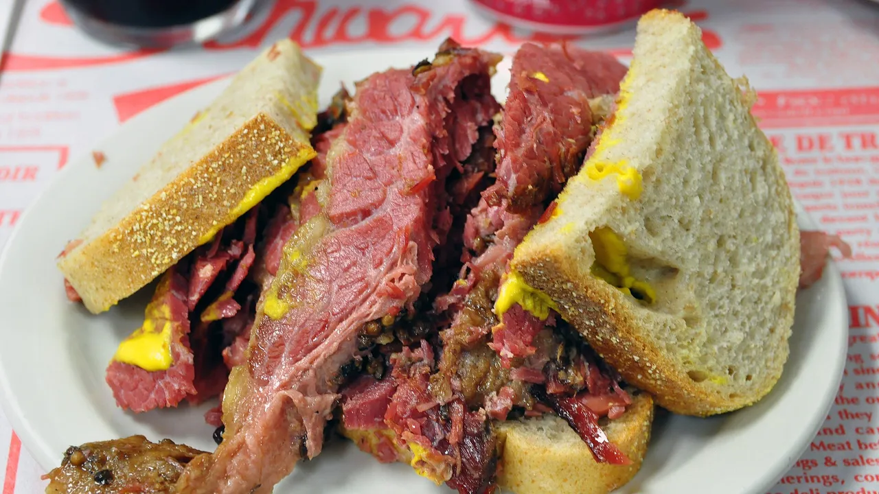A plate of hand-cut medium smoked meat piled between slices of rye at a Montreal deli