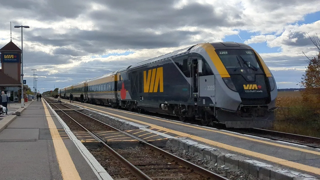 VIA Rail Siemens Venture trainset with cab car 2203 leading, stopped at an outdoor Corridor station platform