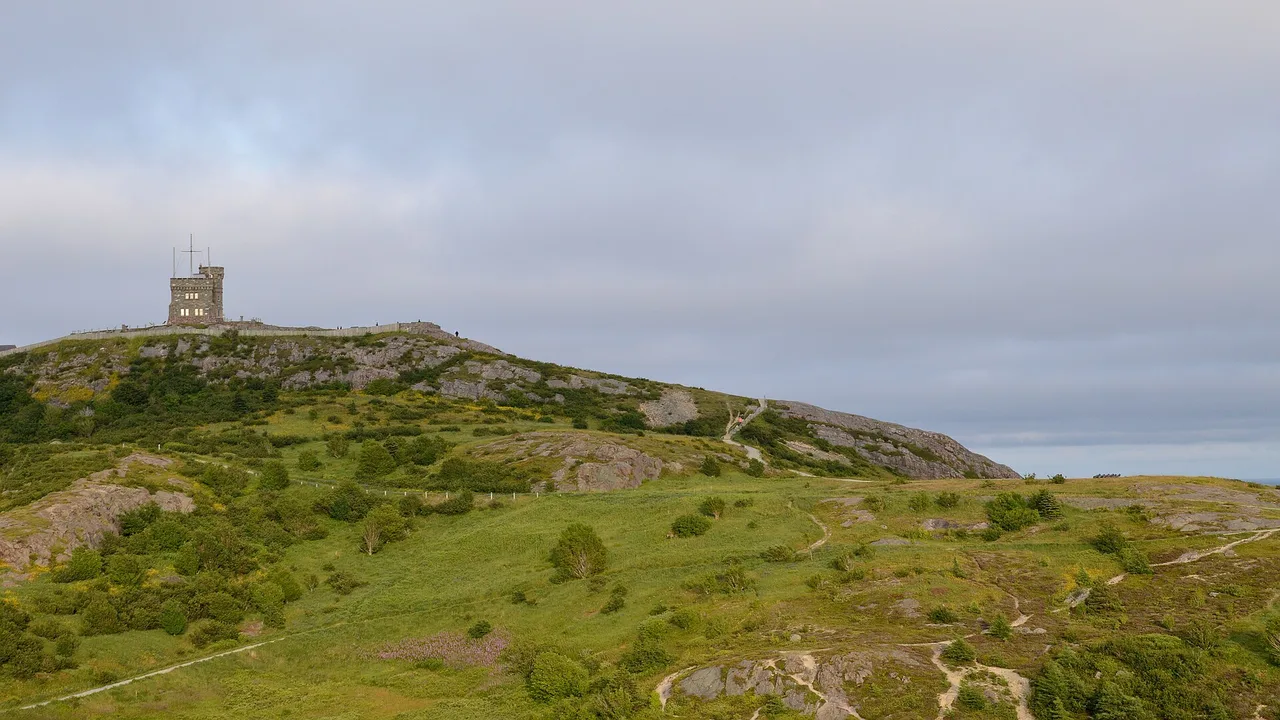 Cabot Tower, a stone tower, on the green and rocky summit of Signal Hill above St. John's