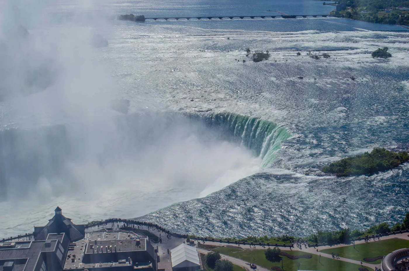 The curved Canadian Horseshoe Falls seen head on from the Ontario shore, mist rising from its crest