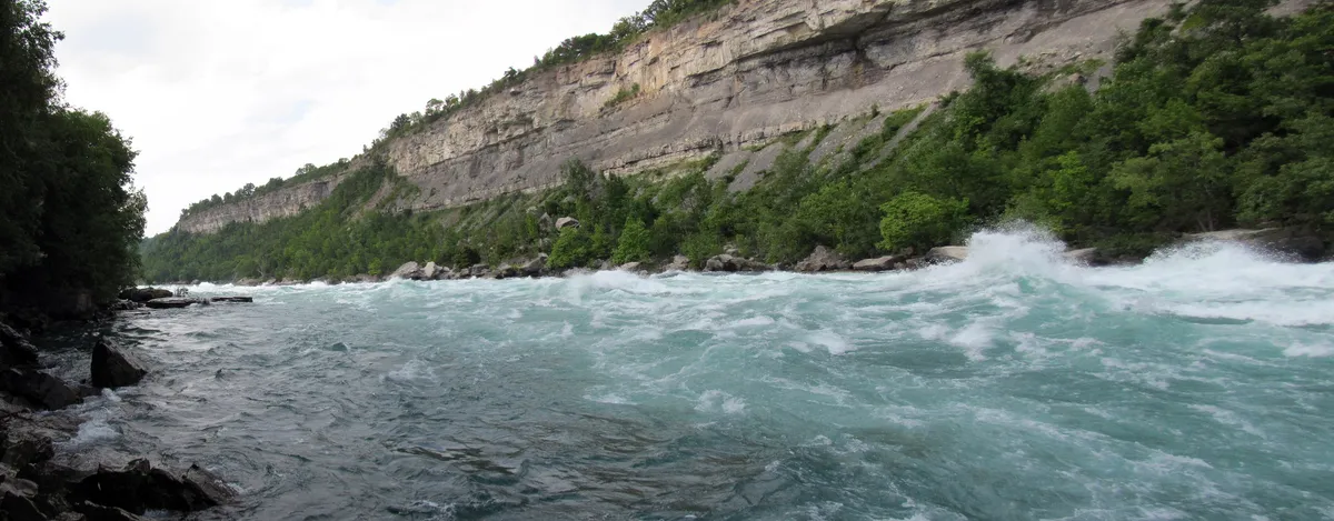 A wooden boardwalk running beside the white rapids of the Niagara gorge on the White Water Walk