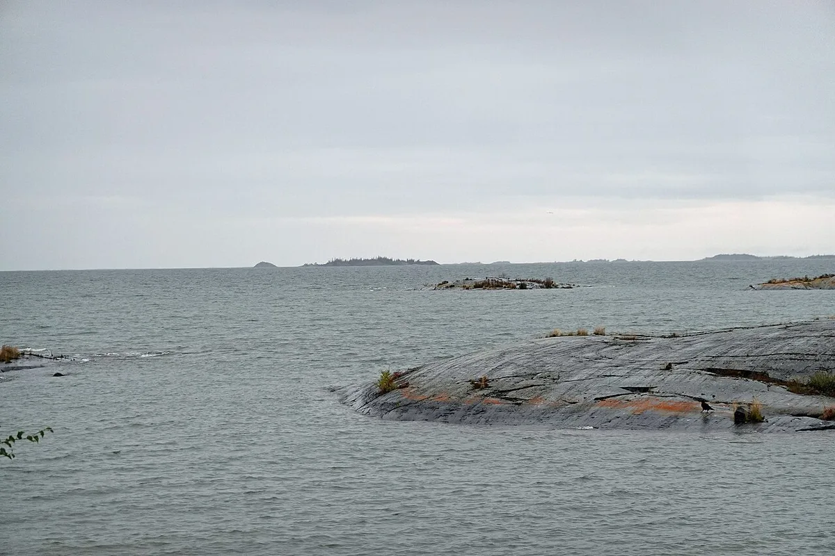 The rocky shore and open water of Great Slave Lake under a wide sky at Dettah near Yellowknife