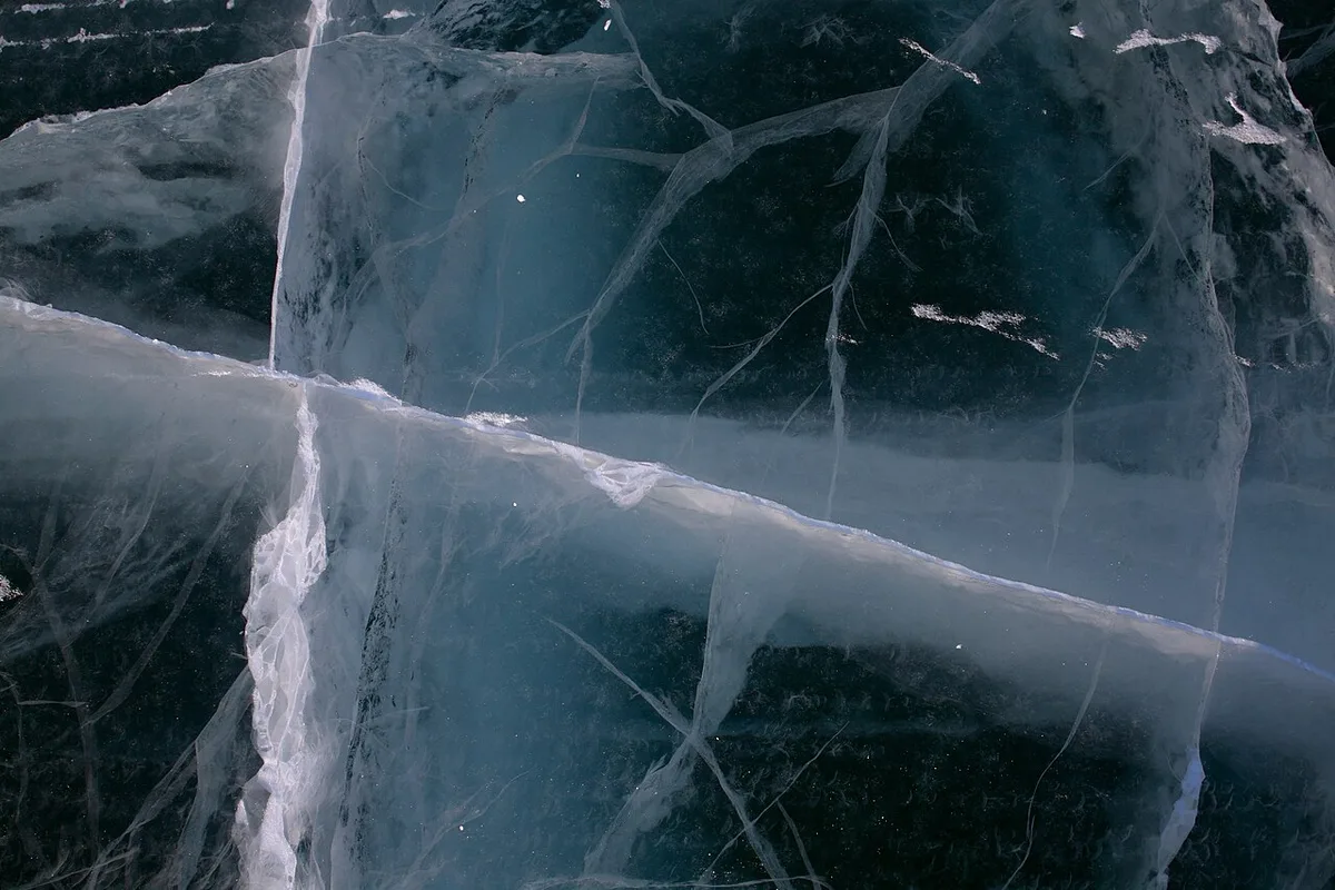 A snow-packed winter ice road stretching straight across a frozen white landscape in the Northwest Territories