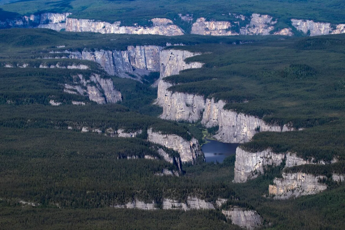 Deep river canyons cutting through forested mountains along the South Nahanni River in Nahanni National Park Reserve