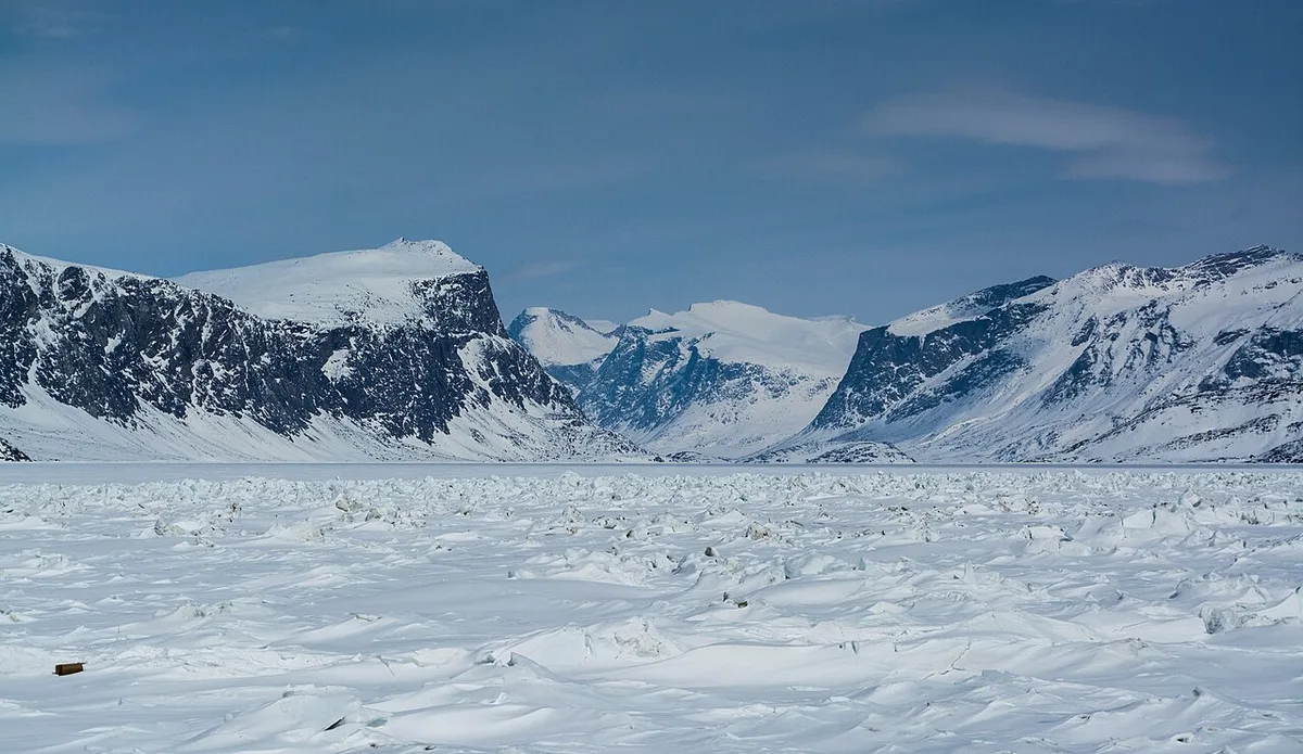 Snow-streaked mountains and a broad valley at the entrance to Auyuittuq National Park seen from Pangnirtung