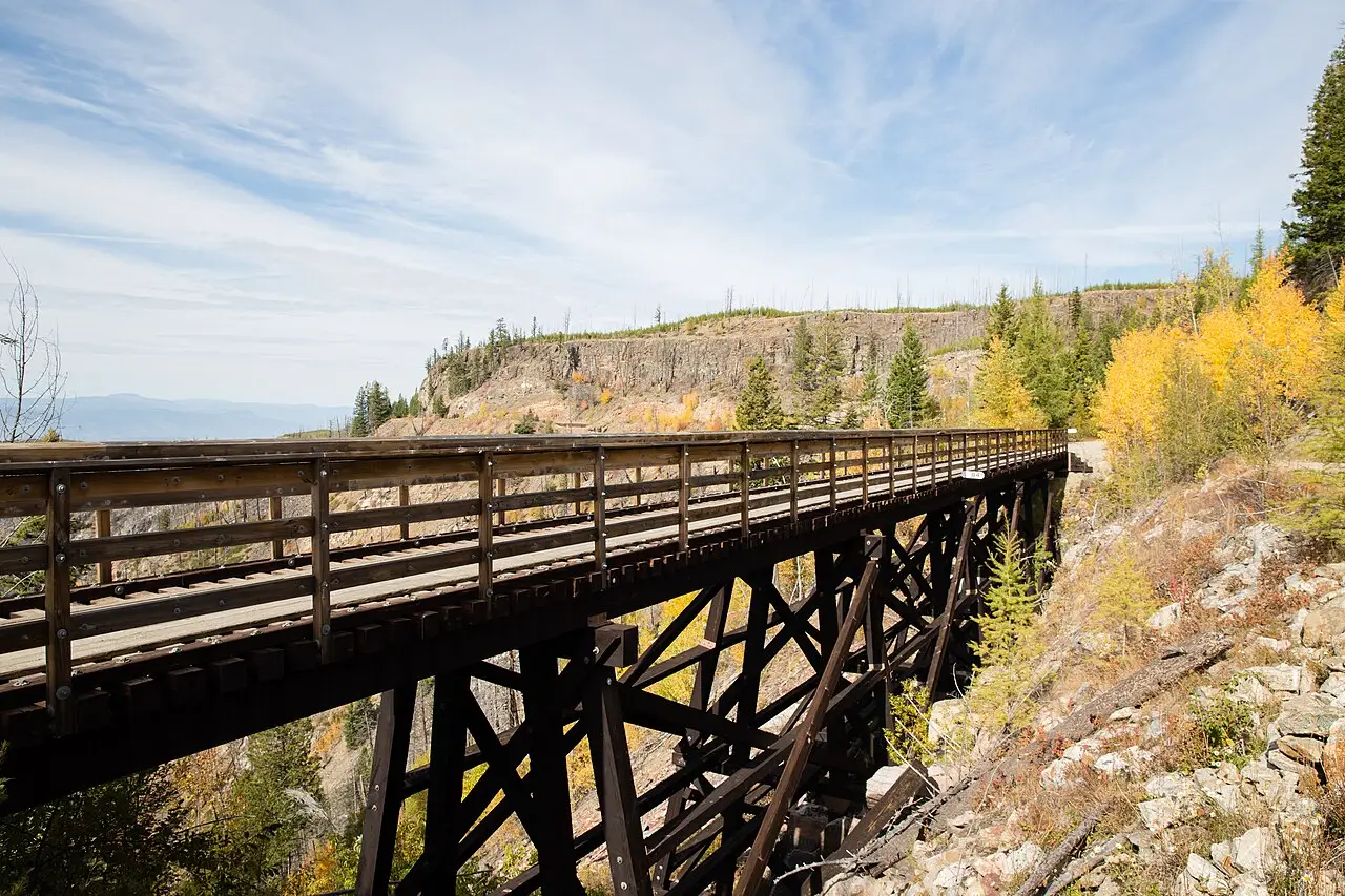 A restored wooden railway trestle curving around the wall of Myra Canyon above Kelowna