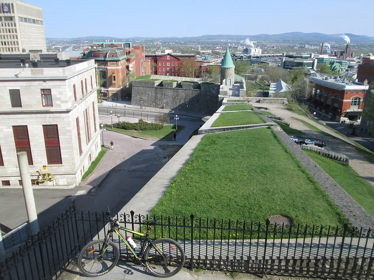 View along the top of the fortified walls of Old Quebec toward a stone bastion and the modern city beyond