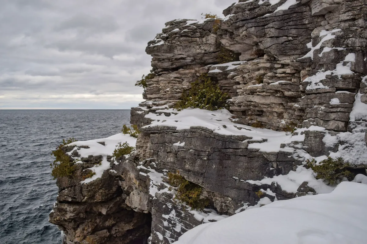 White limestone cliffs above clear turquoise water near the Grotto in Bruce Peninsula National Park