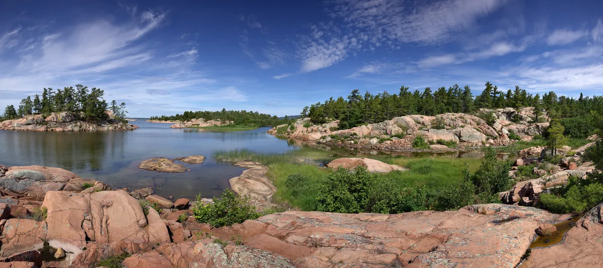 Bare pink and white rock and windblown pines along the Georgian Bay shore in Killarney Provincial Park