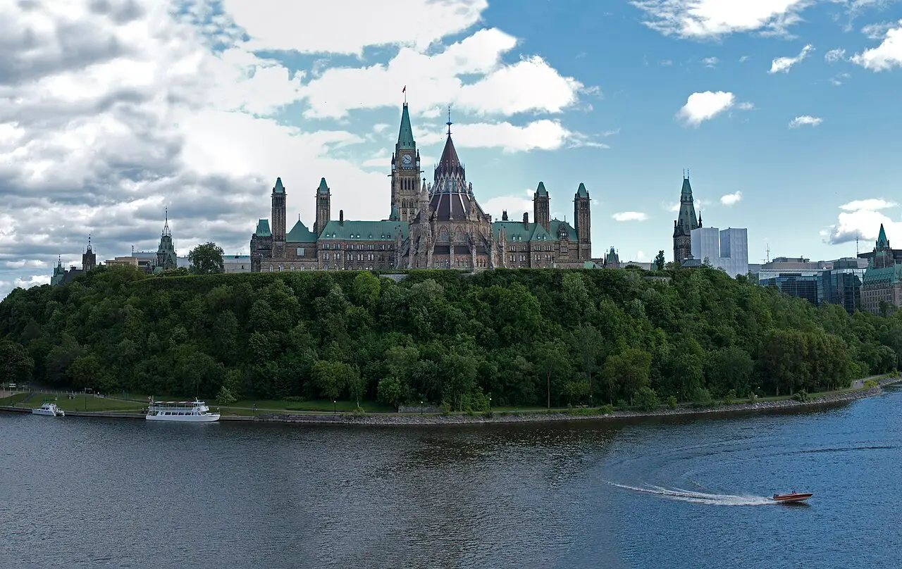 Parliament Hill and the Peace Tower across the Ottawa River under a blue sky