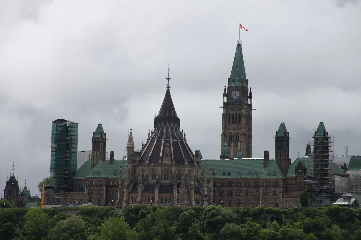 The Peace Tower rising above the Parliament buildings in Ottawa under a blue sky
