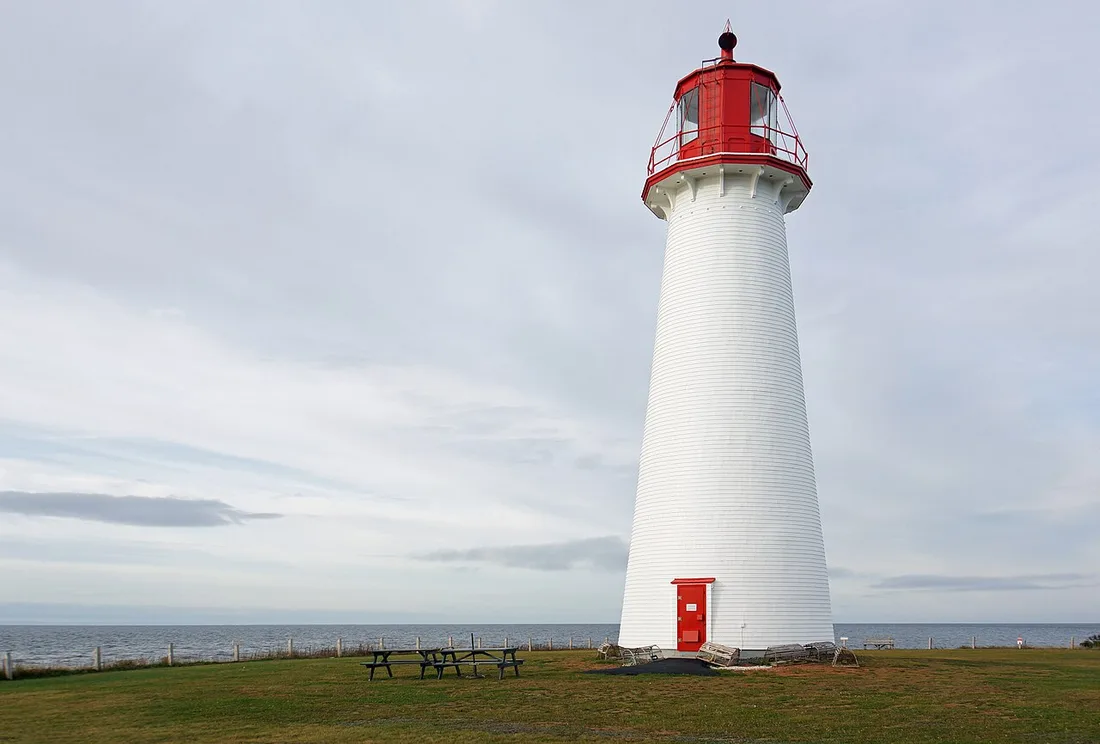 The round white Point Prim Lighthouse standing against a blue sky on the Prince Edward Island shore