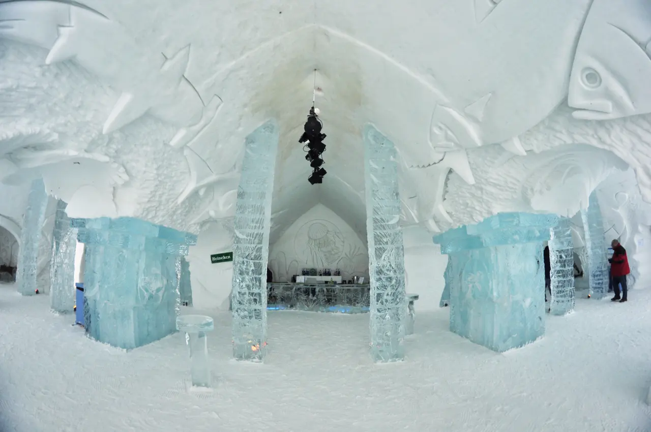 The ice bar inside the Hotel de Glace with carved stools and blue lighting