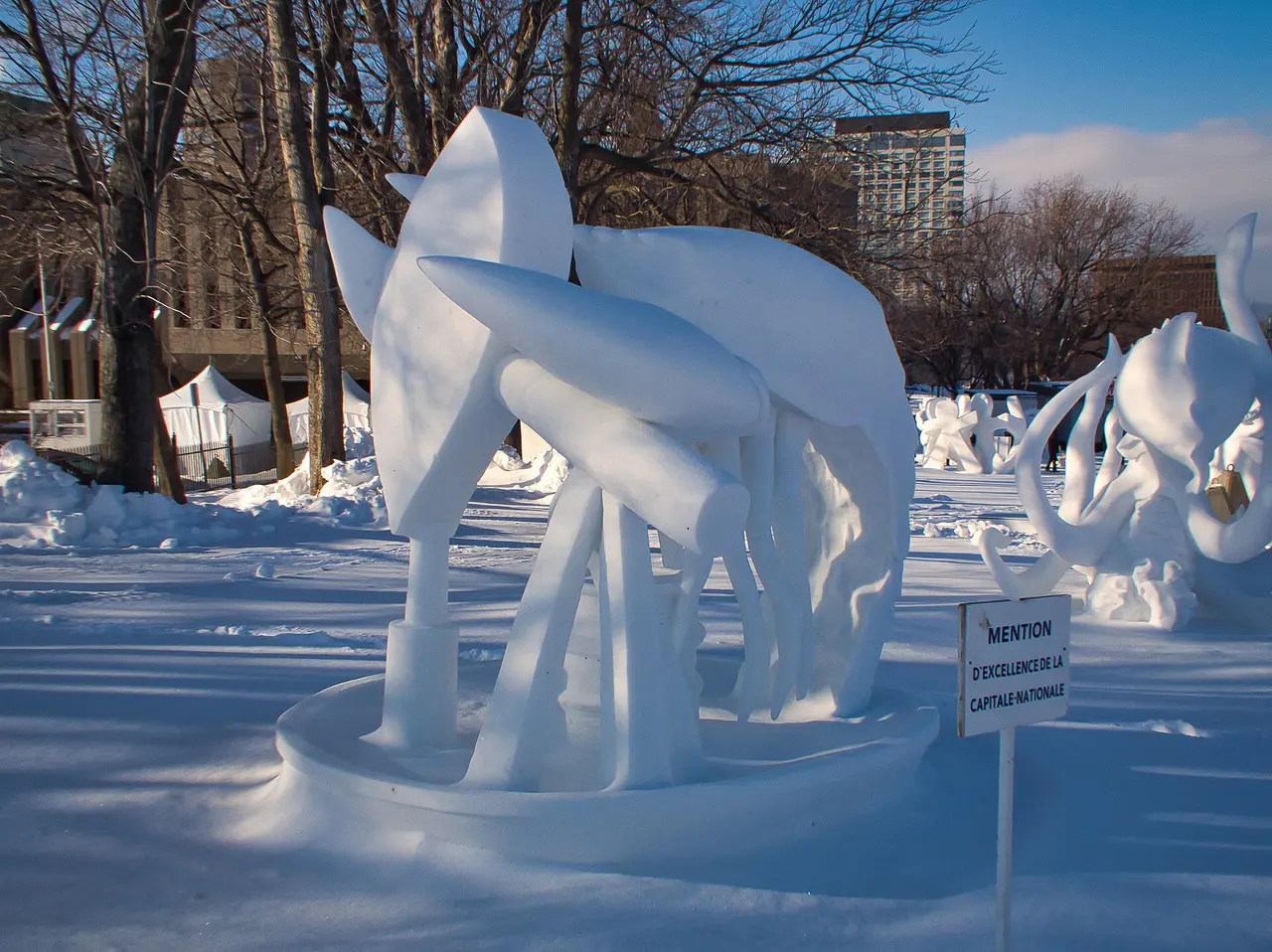 A carved ice sculpture standing outdoors during winter in Quebec City