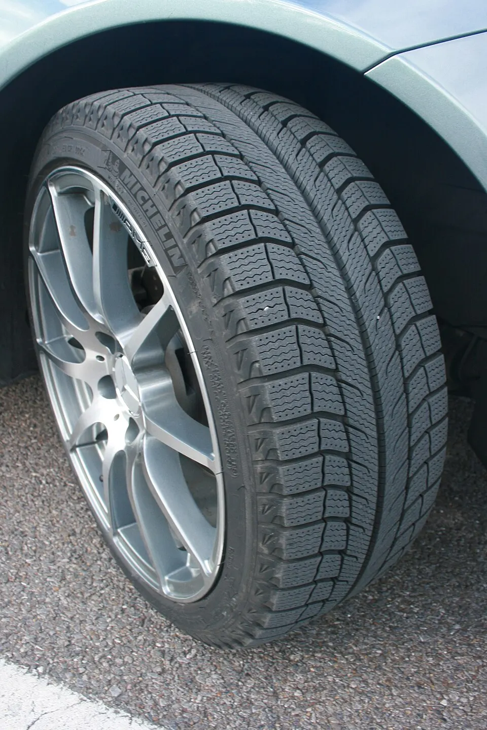 A mounted winter tire with a deep tread pattern designed for cold weather grip