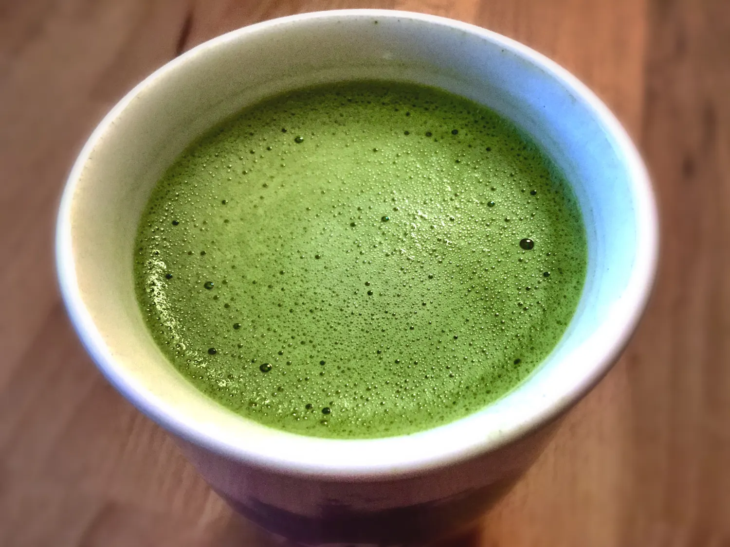 Overhead view of a foamed matcha latte in a white cup, the style of Japanese-inspired drink Neo Coffee Bar is known for