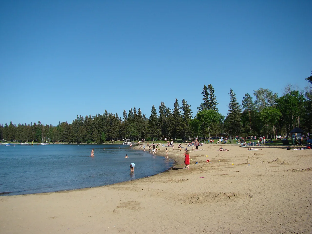 Sandy beach and calm water on Clear Lake in Riding Mountain National Park
