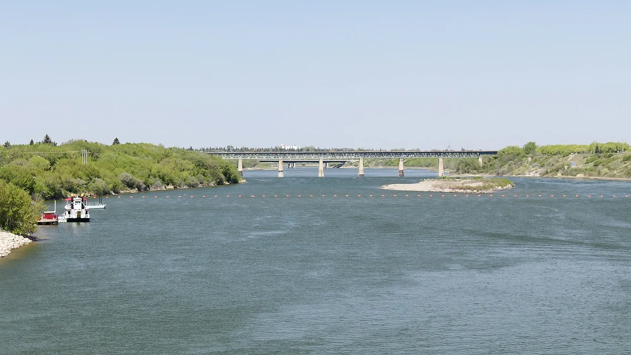 The South Saskatchewan River winding through Saskatoon with tree-lined banks under a wide sky