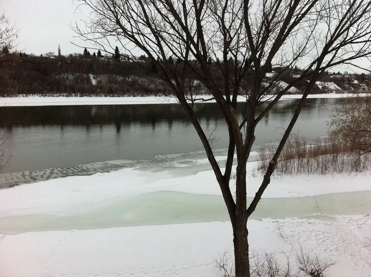 The South Saskatchewan River in Saskatoon with snow on the banks