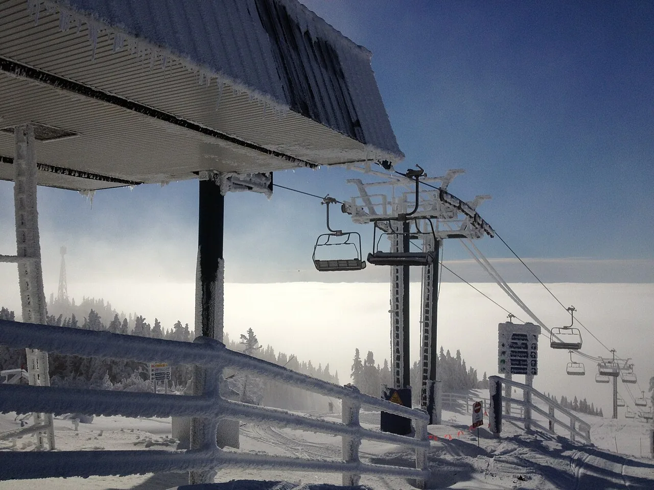A chairlift and station at the summit of Mont Tremblant coated in thick rime ice above a sea of cloud