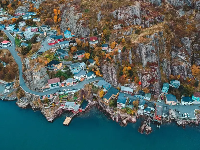 Aerial view of The Battery houses clinging to rock at the harbour mouth