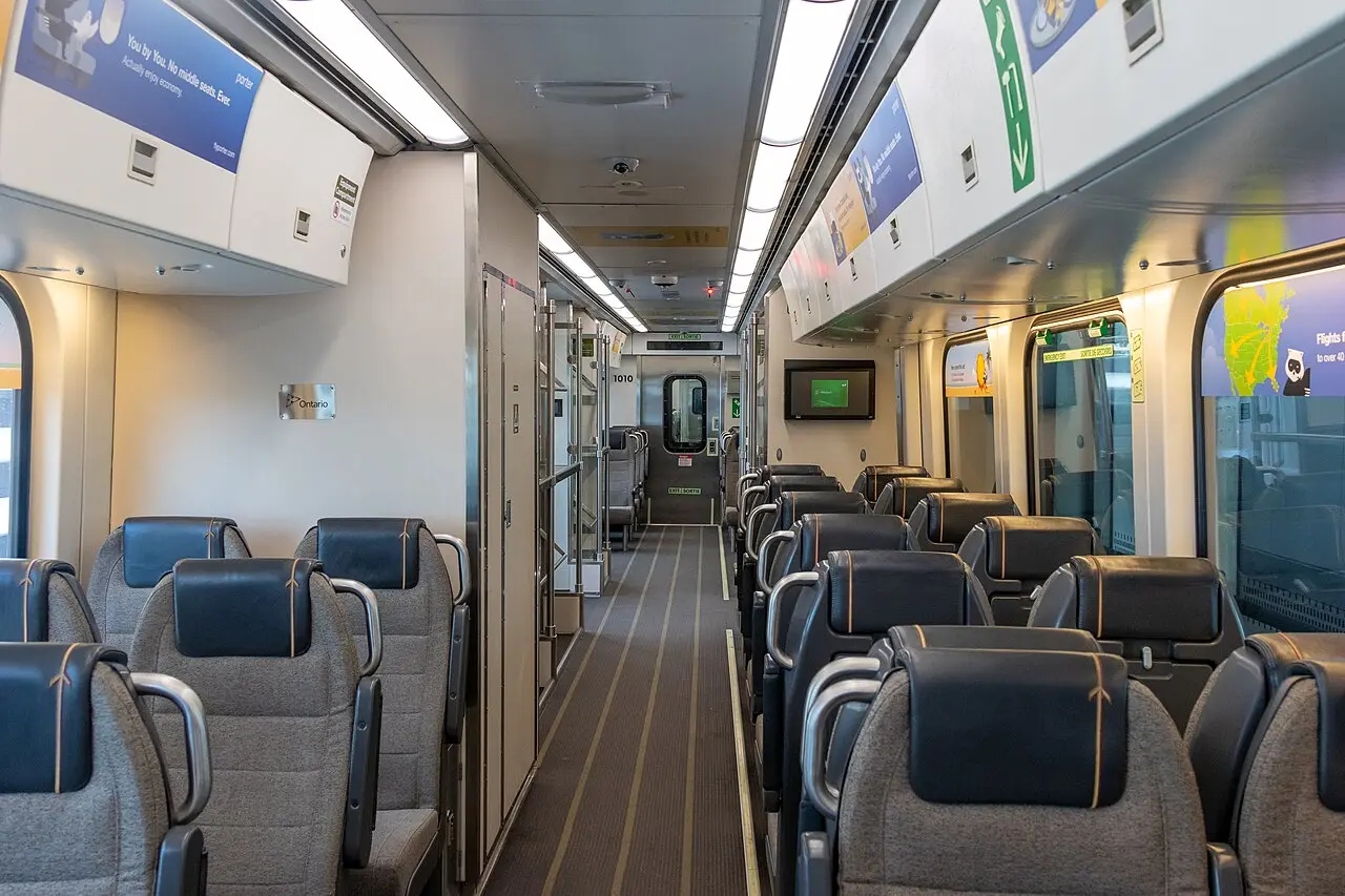 The interior of a UP Express train with luggage racks and two-by-two seating
